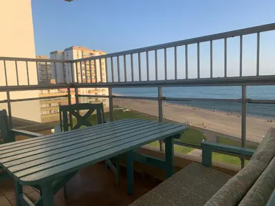 a bench on a balcony with a view of the beach at Apartamento Vista Bahia - Vistahermosa in El Puerto de Santa María