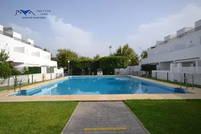 a swimming pool in front of a building at Adosado Familiar con Piscina y Terraza in Cádiz
