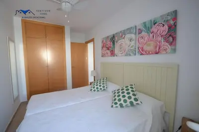 a bedroom with a white bed with two pillows at Adosado Familiar con Piscina y Terraza in Cádiz