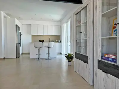 a kitchen with white cabinets and a kitchen with stools at Villa Tresoles - Ole Solutions in Conil de la Frontera