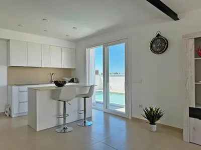 a kitchen with a counter and a clock on the wall at Villa Tresoles - Ole Solutions in Conil de la Frontera