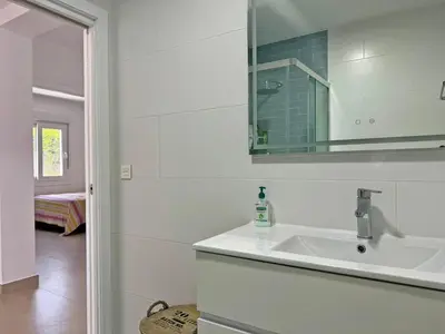 a white bathroom with a sink and a mirror at Villa Tresoles - Ole Solutions in Conil de la Frontera