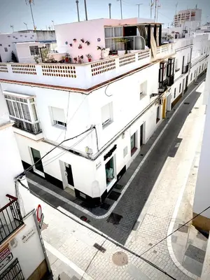 a white building with a balcony on top of it at Casa Castelar in Rota