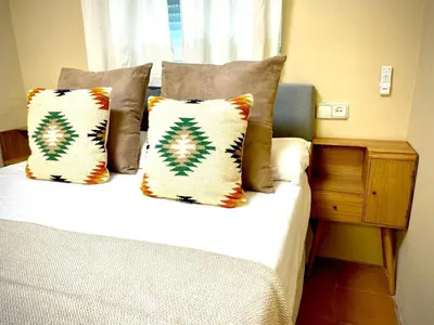 a bedroom with a bed with pillows and a window at Casa Castelar in Rota