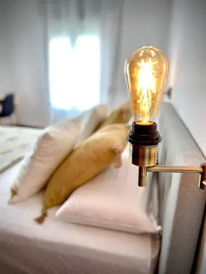 a light on a couch with a pillow and a lamp at Casa Castelar in Rota