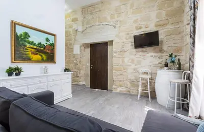 a living room with a couch and a stone wall at Casa Antonia I in Jerez de la Frontera