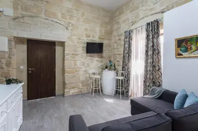 a living room with a couch and a stone wall at Casa Antonia I in Jerez de la Frontera