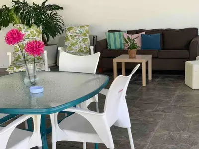 a living room with a table and white chairs at LOS ANTONIOS Loft Rural Chipiona in Cádiz