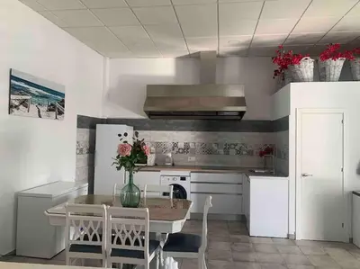 a kitchen with a table and chairs in a kitchen at LOS ANTONIOS Loft Rural Chipiona in Cádiz