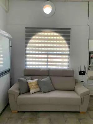 a couch in a living room with a large window at LOS ANTONIOS Loft Rural Chipiona in Cádiz
