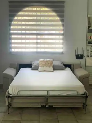 a bed in a room with a large window at LOS ANTONIOS Loft Rural Chipiona in Cádiz