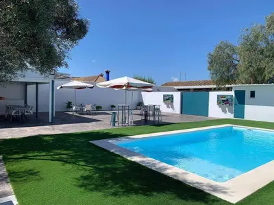 a swimming pool in a yard next to a house at LOS ANTONIOS Loft Rural Chipiona in Cádiz