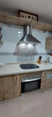a kitchen with a stove and a hood at Apartamento La Porteña, 200 ms de playa Victoria in Cádiz