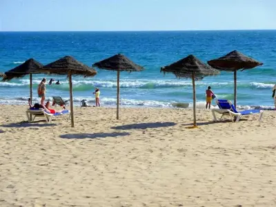 a beach with umbrellas and people on the beach at Apartamento La Porteña, 200 ms de playa Victoria in Cádiz