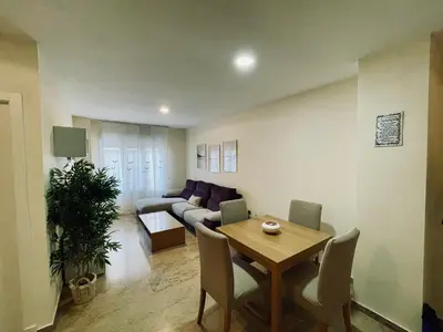 a living room with a table and a couch at Apartamento La Porteña, 200 ms de playa Victoria in Cádiz