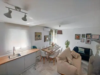 a kitchen and living room with a table and a couch at Barrameda 19 in Sanlúcar de Barrameda
