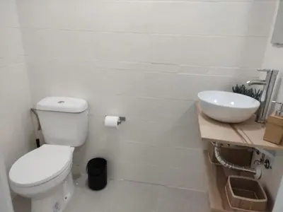 a white bathroom with a toilet and a sink at Barrameda 19 in Sanlúcar de Barrameda
