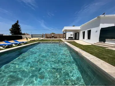 a swimming pool in front of a house at Chalet Namasté in Conil de la Frontera