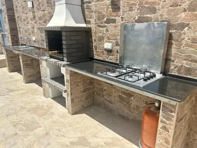 a stone kitchen with a stove and an oven at Chalet Namasté in Conil de la Frontera