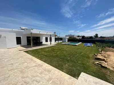 a backyard of a white house with a swimming pool at Chalet Namasté in Conil de la Frontera