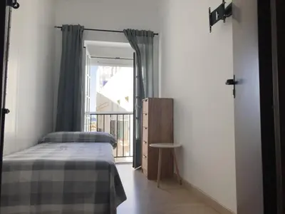 a bedroom with a bed and a window at Casa Carmela - PÓPULO in Cádiz