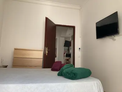 a bedroom with a bed and a flat screen tv at Casa Carmela - PÓPULO in Cádiz