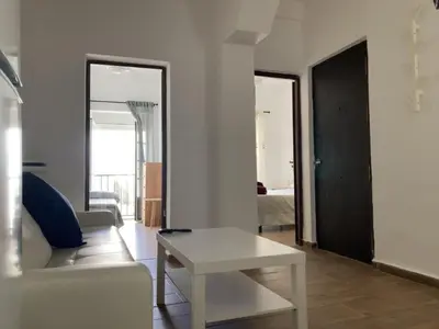 a living room with a white couch and a table at Casa Carmela - PÓPULO in Cádiz