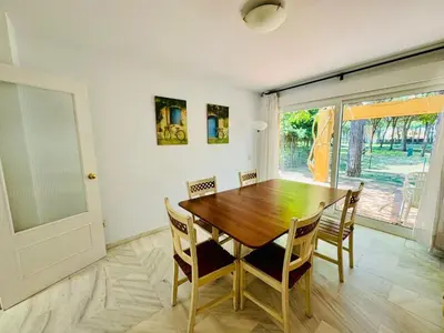 a dining room with a wooden table and chairs at Hoyo 27 con Piscina Grupo AC Gestión in Chiclana de la Frontera