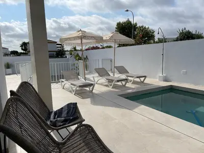 a patio with chairs and a swimming pool at Casa Bahía de Cádiz in Conil de la Frontera