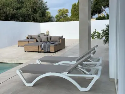 a bed and a lounge chair on a patio at Casa Bahía de Cádiz in Conil de la Frontera