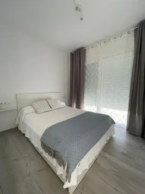 a white bedroom with a bed and a window at Casa Bahía de Cádiz in Conil de la Frontera