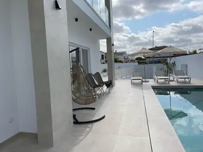a patio with chairs and a swimming pool at Casa Bahía de Cádiz in Conil de la Frontera