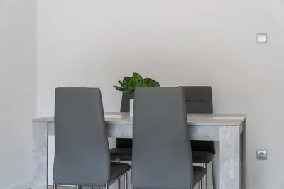 a dining room table with two chairs and a plant at Apartoyou - Pinar Lux in El Puerto de Santa María