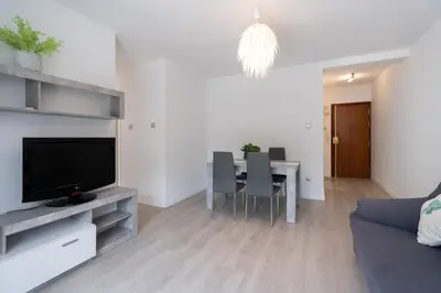 a living room with a table with chairs and a television at Apartoyou - Pinar Lux in El Puerto de Santa María