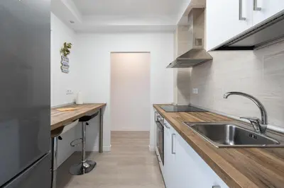 a kitchen with a sink and a wooden counter top at Apartoyou - Pinar Lux in El Puerto de Santa María