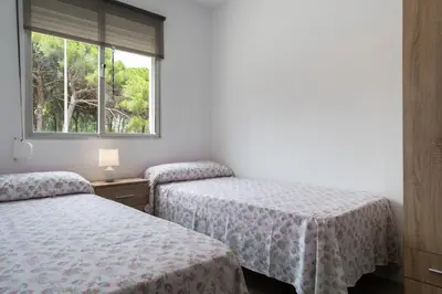 two beds in a room with a window at Apartoyou - Pinar Lux in El Puerto de Santa María