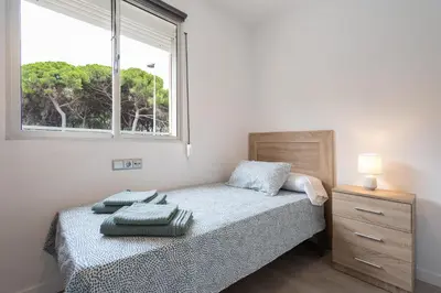 a small bedroom with a bed and a window at Apartoyou - Pinar Lux in El Puerto de Santa María