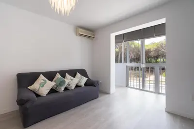 a living room with a couch and a large window at Apartoyou - Pinar Lux in El Puerto de Santa María
