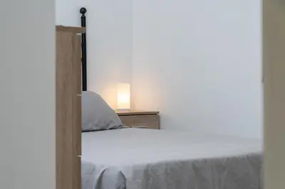 a bedroom with a white bed with a lamp on it at Apartoyou - Pinar Lux in El Puerto de Santa María