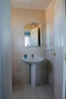 a bathroom with a sink and a mirror at Albatros Sanlucar in Sanlúcar de Barrameda