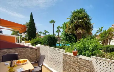 a balcony with a table and chairs and palm trees at Lovely Apartment In Chiclana De La Front in Poblado de Sancti Petri