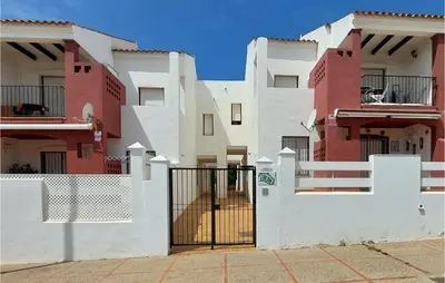 a house with a gate in front of it at Lovely Apartment In Chiclana De La Front in Poblado de Sancti Petri