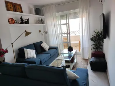 a living room with a blue couch and a table at Casa Bermeo in Sanlúcar de Barrameda