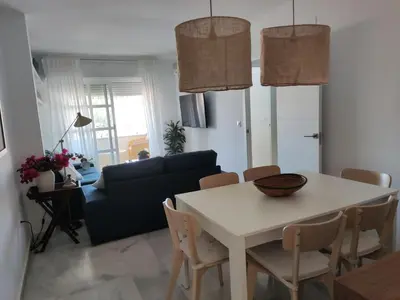 a living room with a table and a couch at Casa Bermeo in Sanlúcar de Barrameda