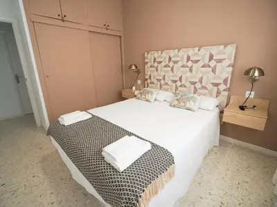 a bedroom with a large white bed with pillows at Sanlúcar Urban Apartment in Sanlúcar de Barrameda