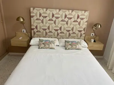 a bedroom with a large white bed with two pillows at Sanlúcar Urban Apartment in Sanlúcar de Barrameda