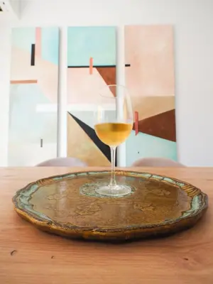 a glass of wine sitting on a plate on a table at Sanlúcar Urban Apartment in Sanlúcar de Barrameda