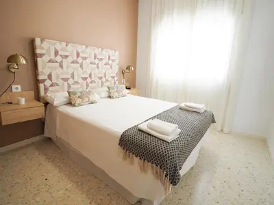 a bedroom with a bed with two towels on it at Sanlúcar Urban Apartment in Sanlúcar de Barrameda