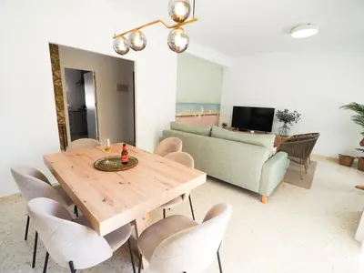 a living room with a wooden table and chairs at Sanlúcar Urban Apartment in Sanlúcar de Barrameda