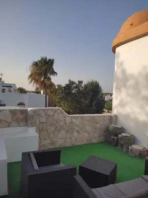 a patio with chairs and a stone wall at APARTAMENTO SEGUNDA PLANTA in Chiclana de la Frontera